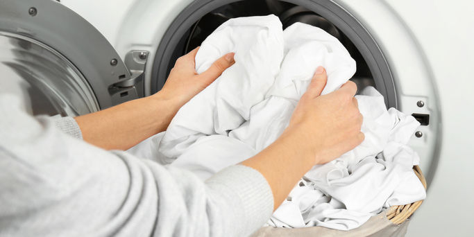 Hands getting out clean clothes from washing machine Hands getting out clean clothes from washing machine